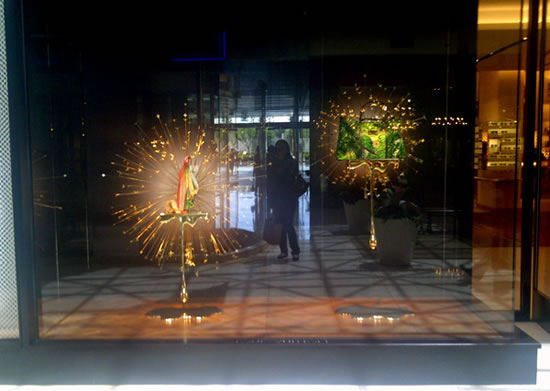 Louis Vuitton window is swarmed with golden bees dripping dazzling