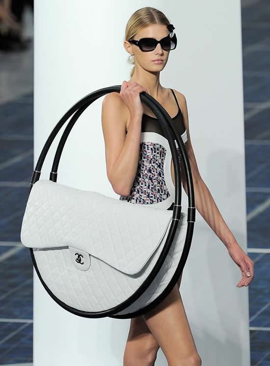 Giant Chanel bag balanced between hula-hoops at Paris Fashion Week